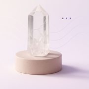 Cristal de roche posé sur un socle beige mat, entouré d’effets visuels doux évoquant la respiration consciente et le bien-être.